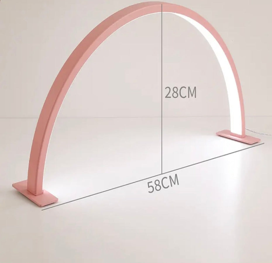 A pink-colored nail light with a curved design, showing dimensions labeled on the image.