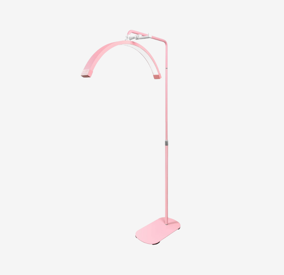 A pink floor lamp with a modern design, including a curved stand and a flat base.