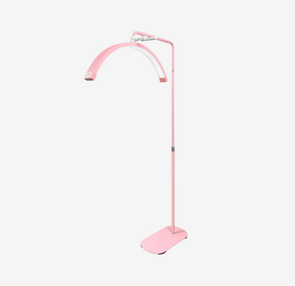 A pink floor lamp with a modern design, including a curved stand and a flat base.