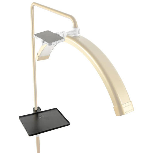 A gold-colored lash tray attachment with a flat base and an adjustable arm, designed for use with cosmetics.